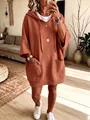 Detail view of an oversized terracotta hoodie featuring two functional front pockets. - S / Tops / Red Brown