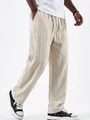 Detailed view of men's cream linen straight-leg drawstring trousers with side pockets. - Off White