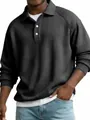 Close-up of a men's dark grey waffle knit long sleeve polo shirt with raglan sleeves - Black