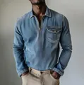 Close-up detail of men's long sleeve half-zip denim shirt with polo collar and chest pocket - Light Blue