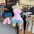 Vista detallada de un top rosa con cuello halter y dobladillo con volantes en tienda - S / Top (HK73257) / Rosa