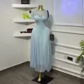 Dettaglio di un elegante abito lungo in pizzo azzurro su un manichino sartoriale - Taglia S / Vestiti / Azzurro