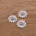 Close-up of three silver sunflower charms for DIY jewelry making on wood background - Antique Silver