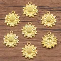 Detailed macro view of small golden sunflower jewelry pendants on a rustic wooden background - Gold
