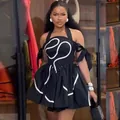 Close-up of black halter neck pleated mini dress featuring white curved line embroidery details - S / Dresses / Black