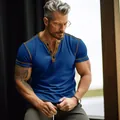 Close-up detail of a premium men's blue short sleeve Henley t-shirt with gold trim accents - S / Tops / Sapphire Blue