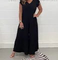 Full view of a black V-neck wide-leg jumpsuit with flutter sleeves on a model. - S / Jumpsuits / Black