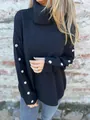 Detailed view of women's black turtleneck sweater featuring decorative sleeve buttons - S / Tops / Black