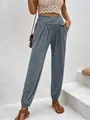 Detail view of grey high-waisted joggers with crossover waist and side pockets - Grey Blue
