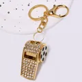 Detailed view of luxury golden rhinestone encrusted whistle keychain with soccer pattern - Football Whistle Keychain / Gold