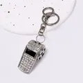 Detailed macro view of a silver rhinestone whistle keychain with soccer motif. - Football Whistle Keychain / Silver