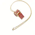 Dettaglio di un ciondolo a fischietto dorato creativo con strass rossi incastonati. - Collana Fischietto Strass Rosso Scuro / Oro