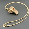 Primo piano dettagliato di una collana con ciondolo a fischietto oro e strass - Collana Fischietto Strass Catena a Spirale / Oro