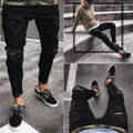 Detailed view of men's black ripped skinny jeans featuring stretch fabric and ankle zippers - S / Bottoms / Black