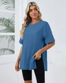 Model wearing a blue loose-fit T-shirt showing the side slit detail and total length - S / Tops / Navy Blue
