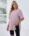 Woman in a loose mauve crew neck t-shirt with side slits and black cycling shorts. - Pink