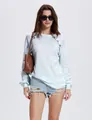 Detailweergave van dames top met lange mouwen in wafelbreisel en knoopdetails op de schouder. - S / Tops / Wit