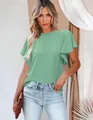 Macro view of light green pleated blouse featuring elegant ruffled sleeves and stand collar - Emerald