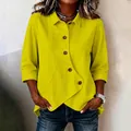 Close-up detail of the unique asymmetrical button design on a bright yellow casual shirt - S / Tops / Yellow