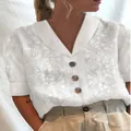 Détail de la blouse blanche à col en V avec broderie florale et boutons marrons - S / Hauts / Blanc