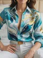 Close-up of vibrant blue and gold marble print on women's long sleeve button-up shirt. - S / Tops / Sky Blue