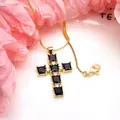 Close-up of a gold-plated copper cross pendant set with black square zircon stones and white gems - Necklace / Black