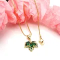 Close-up macro detail of a delicate gold maple leaf pendant inlaid with green zircon stones - Green Pendant With Necklace / Gold