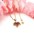 Detailed view of gold maple leaf pendant with red cubic zirconia on box chain necklace - Red Pendant With Necklace / Gold