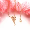 Primo piano di una collana con ciondolo a farfalla con zirconi rosa su catena placcata oro. - Set Collana con Ciondolo / Rosa