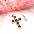 Detailed macro view of a gold cross necklace with black cubic zirconia on pink tissue paper. - Necklace Set / Black