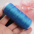 Detailaufnahme von 0,5 mm schimmerndem blauem flachem Wachsfaden für DIY-Schmuck. - Seenebel 75844