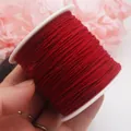 Detailansicht einer roten 0,8 mm Baumwollschnur auf einer weißen Kunststoffspule - 0.8mm / Tibetisch-Rot