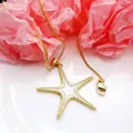 Detailed view of a gold-colored starfish pendant necklace featuring a box chain and clasp. - Gold Starfish Pendant Necklace
