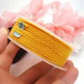 Yellow braided cotton cord with metallic gold thread on white plastic spool - Approximately 1.2mm / 18# Yellow with Gold