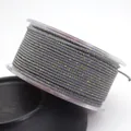 Detailed macro view of 1.5mm gray Milan cord with gold metallic silk thread on clear spool - Approx. 1.5MM / Dark Gray
