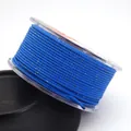 Detail view of 1.5mm blue Milano cord with gold metallic flecks wrapped on a clear spool - Approx. 1.5MM / Sapphire Blue