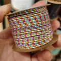 Hand holding a spool of vibrant purple and yellow multi-color braided cotton thread - Four-Strand Colorful Style (A29) / Approx. 2.0mm / Purple White Yellow Green Mix