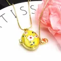 Close-up of gold-plated oval locket necklace with yellow enamel and white flower pattern. - Necklace Set / Yellow