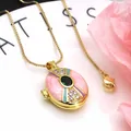 Close-up macro view of a vintage pink enamel locket pendant necklace with zircon stones - Necklace Set / Pink and Green