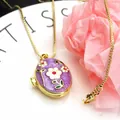 Detail view of a gold-plated oval locket necklace with purple floral enamel design. - Necklace Set / Purple