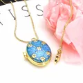 Macro detail of an oval gold-plated locket necklace with blue enamel and flower motifs - Necklace Set / Blue B