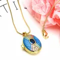 Detailed view of a gold-plated oval locket necklace with blue enamel and sparkling zircons. - Necklace Set / Blue