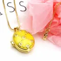 Close-up of a gold-plated oval locket necklace with yellow enamel and flower patterns - Necklace Set / Yellow B