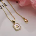 Detail view of a gold initial 'A' necklace with shell inlay and zircon border - Letter A