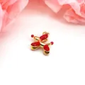 Detailed macro view of a vibrant red and gold enamel balloon dog charm for bracelets - Red