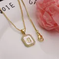 Close-up detail of gold letter C pendant with mother-of-pearl and sparkling zircons - Letter C