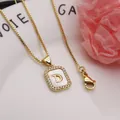 Close-up of gold shell initial D pendant necklace with cubic zirconia detailing. - Letter D