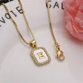 Detailed close-up of square initial E pendant necklace with zircon and shell inlay - Letter E