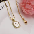 Close-up of gold square letter H pendant necklace with shell and pavé zircon inlay - Letter H