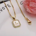 Close-up of square gold pendant necklace with shell inlay and letter L detail - Letter L